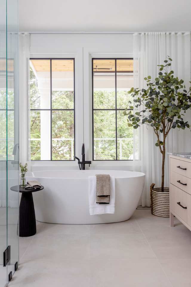 natural tile in organic bathroom with deep soak tub and potted plant